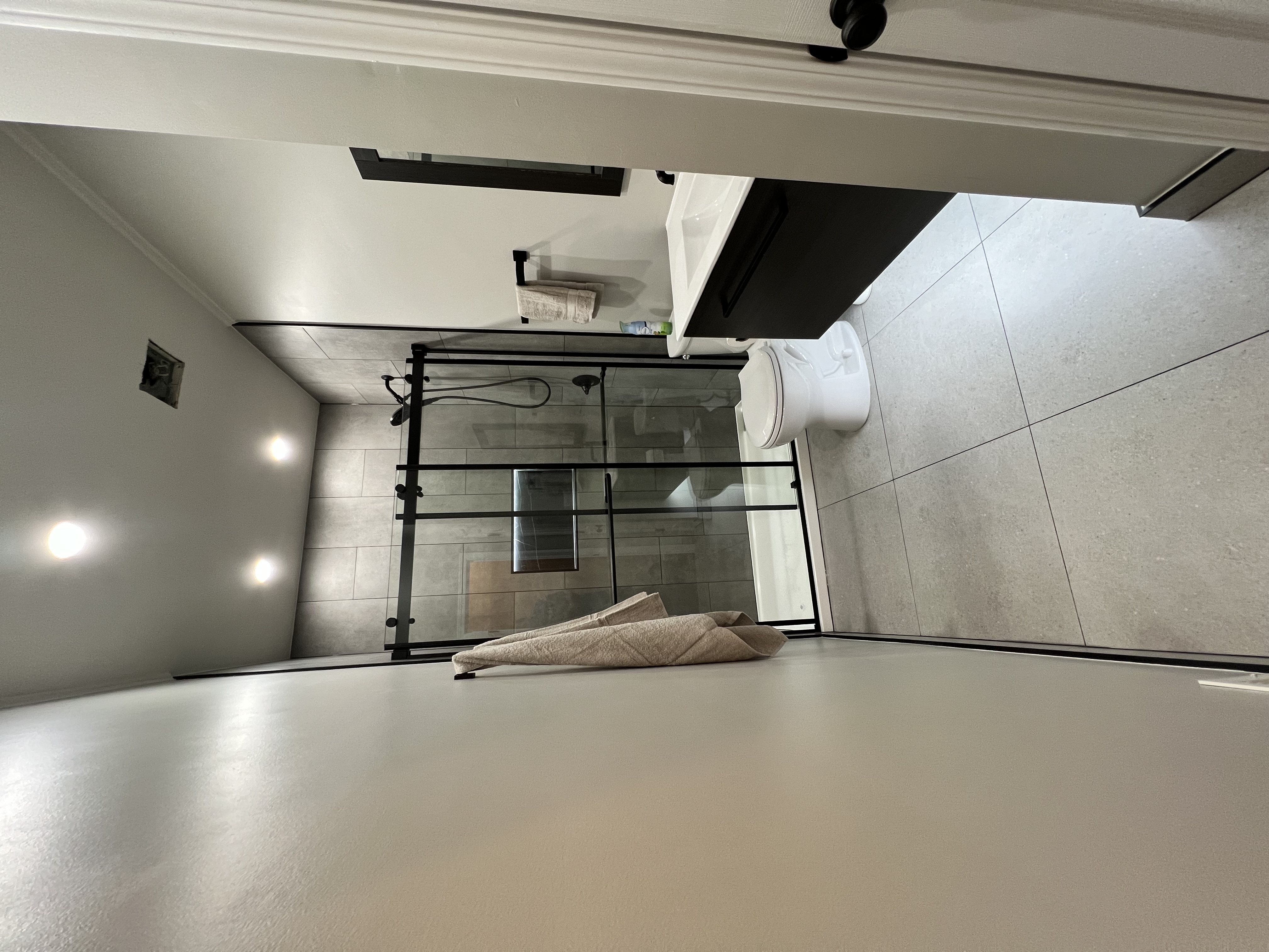 Bathroom remodel electrical work with modern glass shower and lighting